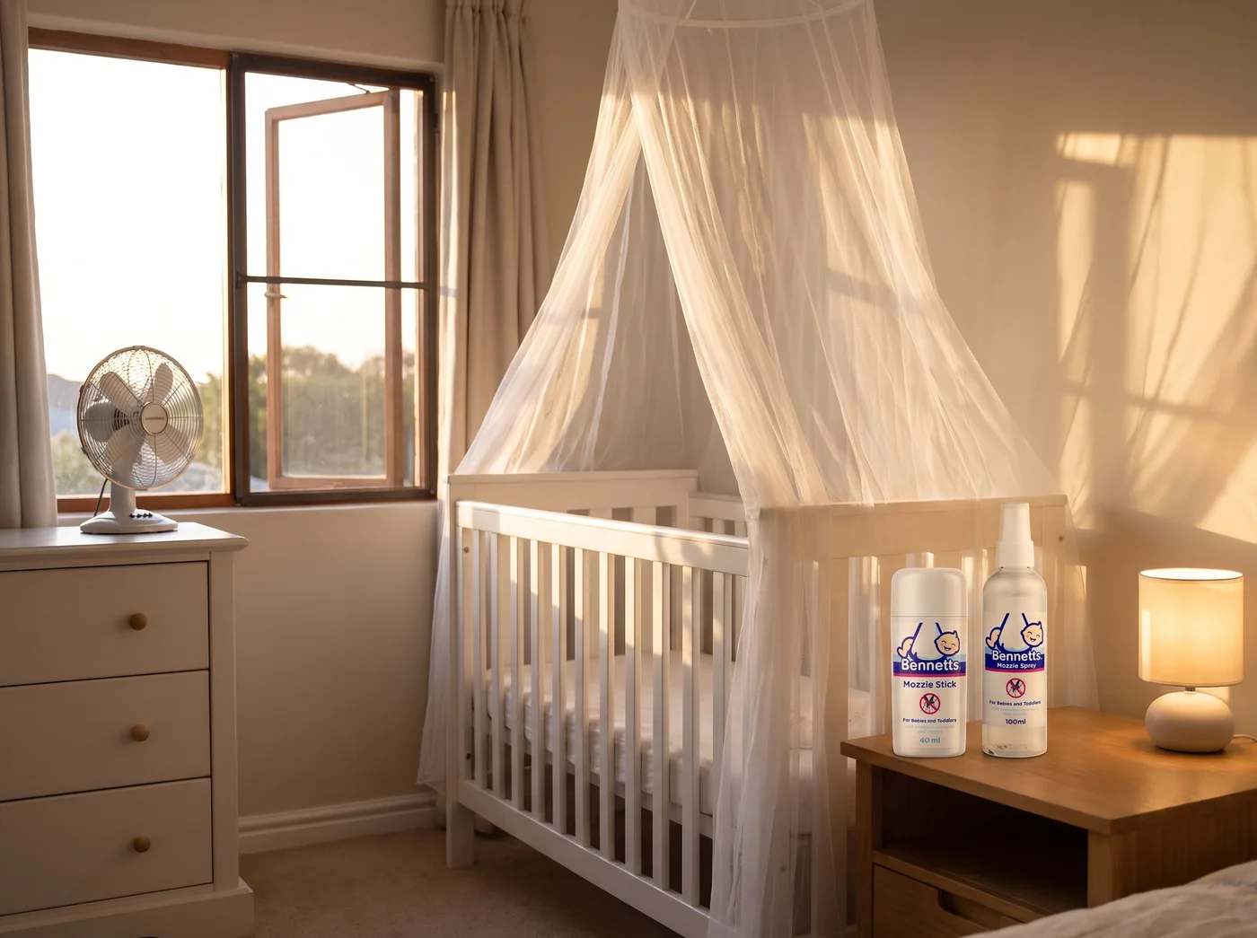 A cot under a mosquito net in a nursery at dusk, with a Bennetts Mozzie Stick and Mozzie Spray on the bedside table